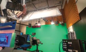 समाचार स्टूडियो में कैमरा, लाइटिंग और ग्रीन स्क्रीन के साथ प्रसारण की तैयारी