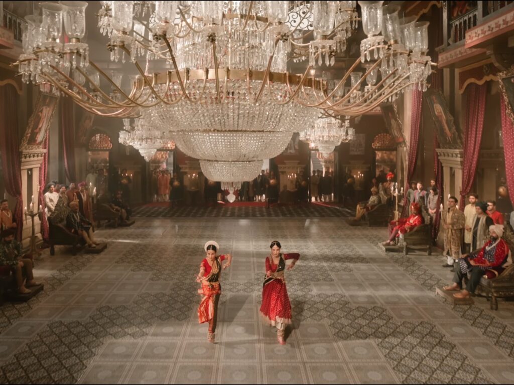 भव्य दरबारनुमा सेट में पारंपरिक परिधानों में शास्त्रीय नृत्य करती कलाकार, भारतीय सिनेमा का दृश्य