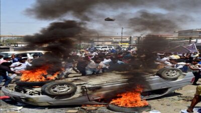 नोएडा में मजदूरों का हिंसक प्रदर्शन, सड़क पर पलटी कार में आग और उठता काला धुआं