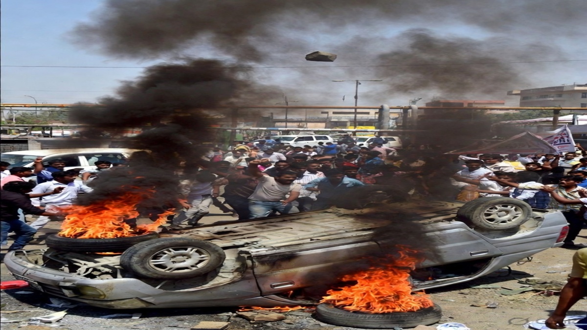 नोएडा में मजदूरों का हिंसक प्रदर्शन, सड़क पर पलटी कार में आग और उठता काला धुआं