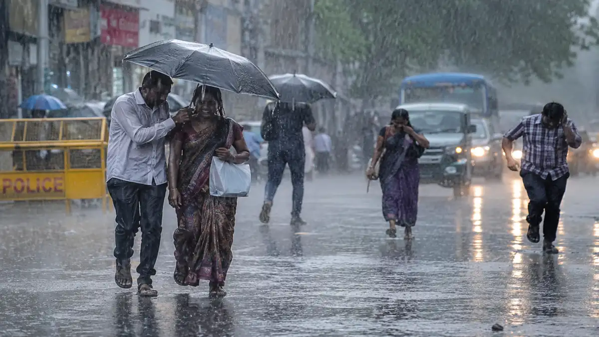 Heavy Rainfall And Monsoon Arrival Scene In India 2026 भारी बारिश के दौरान सड़क पर भीगते लोग, मानसून 2026 की प्रतीकात्मक तस्वीर