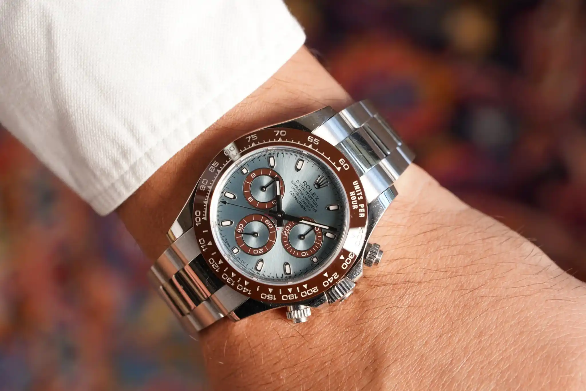 हाथ में पहनी हुई सिल्वर Rolex Daytona प्रीमियम लक्ज़री घड़ी